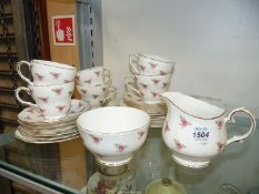 A Duchess china tea set (no teapot) decorated with pink roses sprigged all over.