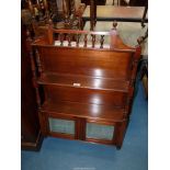 An Edwardian Mahogany wall hanging Shelf Unit having turned supports and spindles to the pediments,