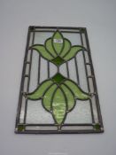 A leaded glass panel with green design. 46" long x 10" wide.