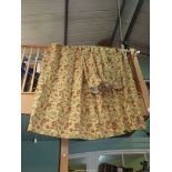 A pair of lined pencil pleat curtains in an open weave fabric in terracotta, green and gold colour,