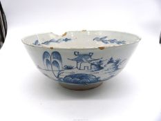 A mid 18th century English Delft punch bowl painted with landscape scenes, large chip,