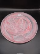 A large glass charger in pink and white swirl design, 20'' diameter.