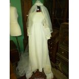 An ivory coloured Wedding Dress with long sleeves having lace overlay to bodice,