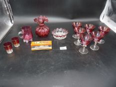 A small quantity of cranberry glass including set of six glasses, small jug, frill rimmed vase etc.