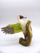 A limited edition figure of a Woodpecker stretching wing on a trunk, no.