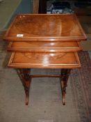 A Nest of Three spindle legged Occasional Tables, the tops with oval Burr wood centres,