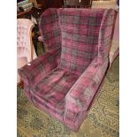 An as new wing Fireside Chair upholstered in subdued maroon, brown and black tartan style fabric.