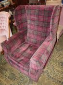 An as new wing Fireside Chair upholstered in subdued maroon, brown and black tartan style fabric.