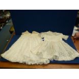 Two Christening gowns in ivory floral lace pattern, one with cream bodice, one with short sleeves,