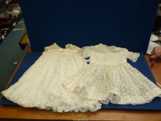 Two Christening gowns in ivory floral lace pattern, one with cream bodice, one with short sleeves,