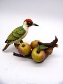 A limited edition figure of a Woodpecker on a branch with three cider apples,