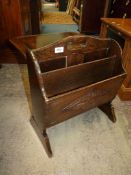 A metamorphic Oak magazine Rack with fretworked loop handle and a carved domed design to the front,