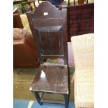 A dark Oak high back Hall Chair having a solid seat and raised and fielded panel to the back,