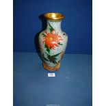 A Cloisonne vase with stylised prunus and chrysanthemums on a blue ground standing on a wooden