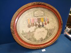An ornate oval framed En Memoire De La Grande Guerre 1914-1918 containing Medals belonging to;