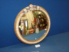 A small circular Barbola convex mirror with encrusted flowers, 12" diameter.
