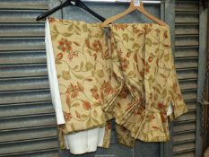 A pair of lined pencil pleat curtains in an open weave fabric in terracotta, green and gold colour,