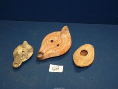 Three ancient terracotta oil lamps.