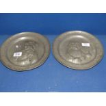 A pair of Pewter display plates with raised design of a card player and a drinker, no marks to base,