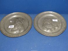 A pair of Pewter display plates with raised design of a card player and a drinker, no marks to base,