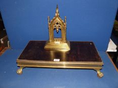 A brass Gothic picture frame and a brass hot plate.