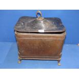 A metal coal box having a hammered finish standing on four feet with drop ring handles (one