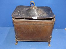 A metal coal box having a hammered finish standing on four feet with drop ring handles (one