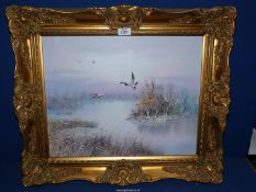 A gilt framed Oil on canvas depicting Ducks flying over a Pond at Sunset,