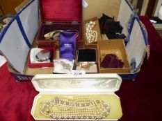 A quantity of costume jewellery in a jewellery box including simulated pearls, earrings, necklaces,