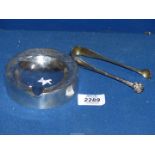 A continental silver lion paw sugar tongs, marked 800 and a 925 circular ashtray with wooden base.