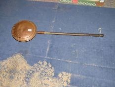 A Copper bed warming pan with turned handle.