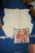 Two sheepskin rugs and a cushion.