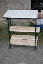 Enamel topped table with two shelves, 23'' x 14'' x 31'' high.