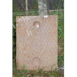 A heavy duty cast iron manhole cover, 20'' x 26''.