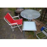 Two glass topped tables and a folding chair.