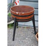 A wooden barrel planter on three wooden legs, 23'' diameter x 29 1/2'' high overall.