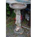 A concrete bird bath in the form of a Putti, 30'' high x 17'' diameter.