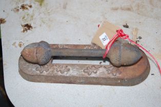 A cast iron boot scraper with acorn ends.