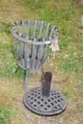 A metal brazier and parasol stand.