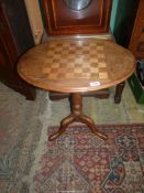 A circa 1900 mixed woods oval chequerboard topped Occasional Table standing on a turned pillar and