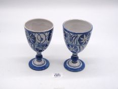 A pair of Alan Caiger-Smith pottery goblets in blue and white, with stylized flowers,