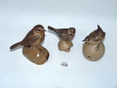 Three Poole Pottery birds including Blue Tit on mushroom, Robin on a pot and Wren on an apple.
