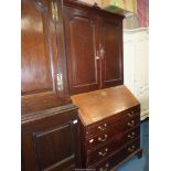 A most useful Oak bureau bookcase the top with a pair of opposing raised and fielded panelled doors