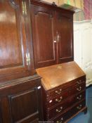 A most useful Oak bureau bookcase the top with a pair of opposing raised and fielded panelled doors