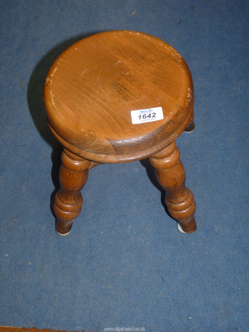 A light Oak/other woods circular stool standing on turned legs with a cross stretcher,