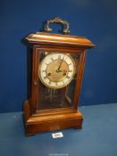 A wooden cased mantle Clock with key, 14'' x 7 1/2''.