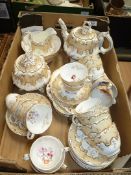 A quantity of teaware including; cream and gold teapot having floral design, cups, saucers,