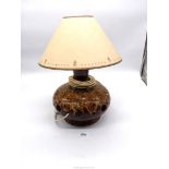 A brown glazed pottery lamp with cut out holes. 15 1/2" tall including shade.