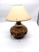 A brown glazed pottery lamp with cut out holes. 15 1/2" tall including shade.