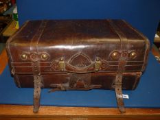 A vintage brown leather Trunk with tooled detail to the fastenings and marked "solid leather" to